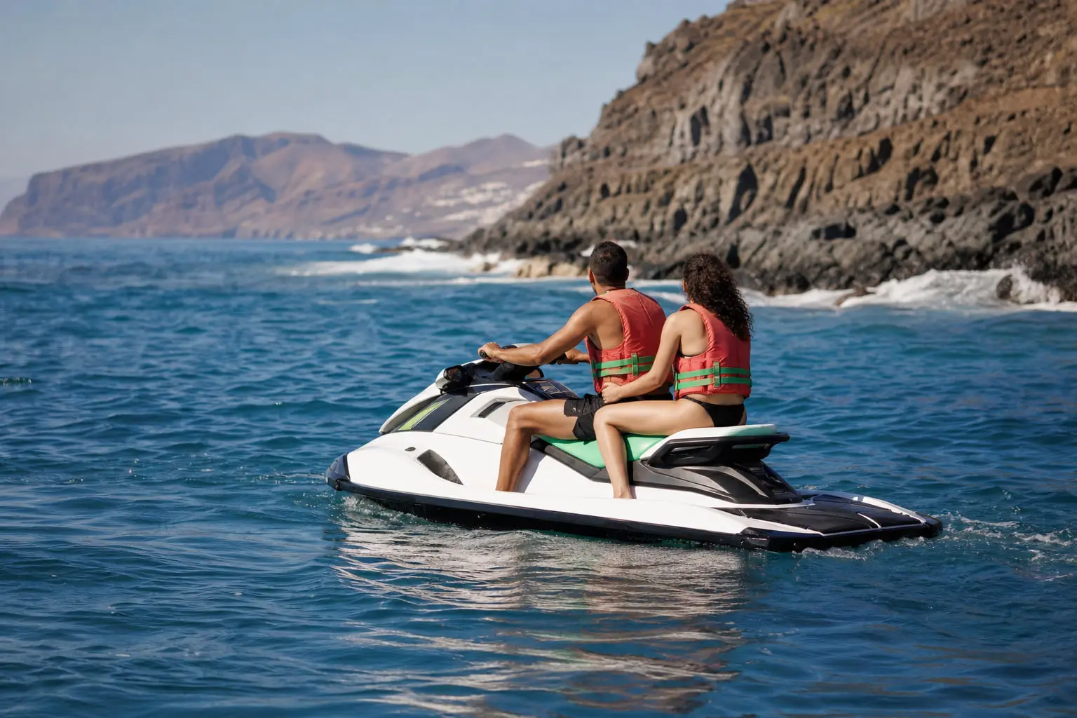 Deux personnes correctement installées sur un jet ski trois places au large de la côte sud de Tenerife.