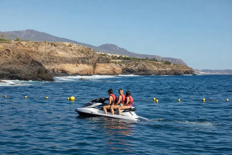 Jet ski trois-places naviguant calmement le matin au large de Costa Adeje à Tenerife.