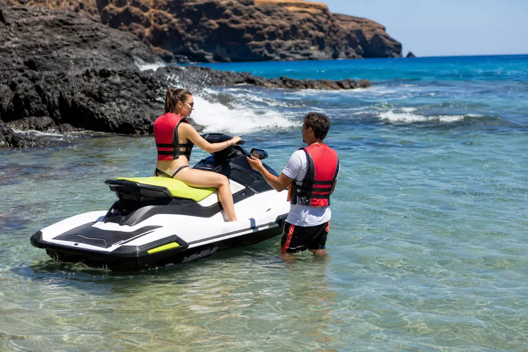 Débutant en gilet de sauvetage sur une moto nautique dans un chenal balisé à Costa Adeje, Tenerife