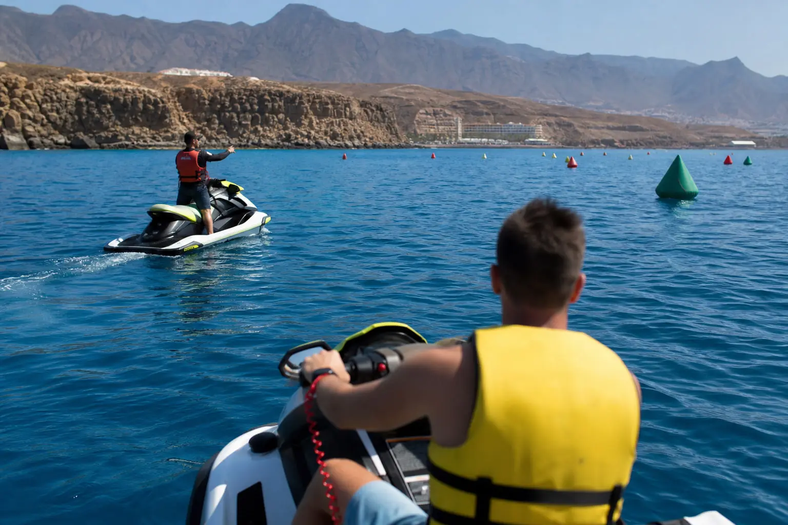 Débutant équipé d’un gilet sur une moto nautique près d’un circuit balisé au large de Puerto Colón à Tenerife.