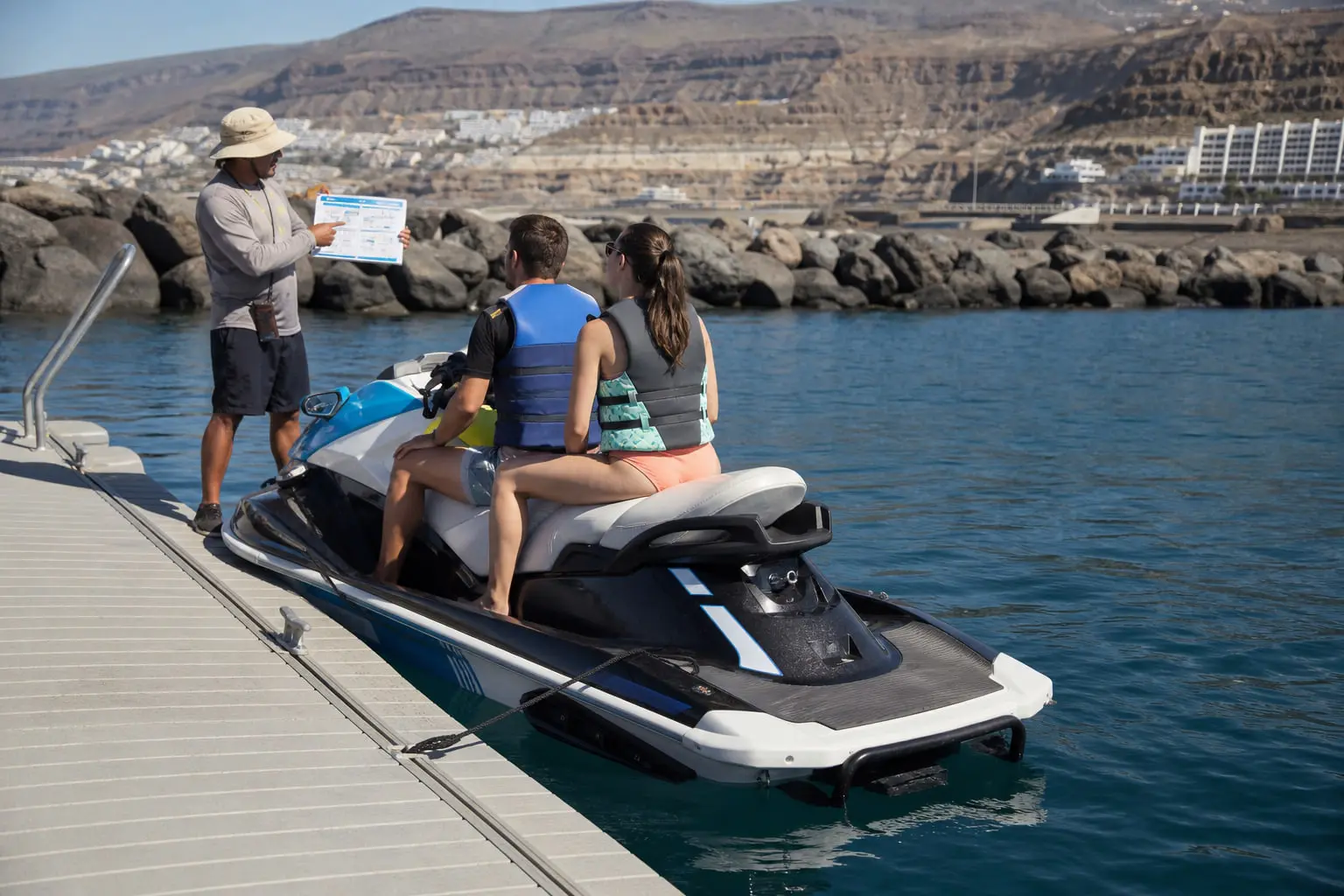 Contrat de location et documents d’assurance vérifiés avant un départ en jet ski à Puerto Colón, à Tenerife.