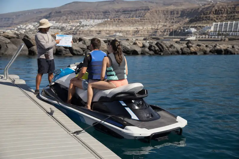 Contrat de location et documents d’assurance vérifiés avant un départ en jet ski à Puerto Colón, à Tenerife.