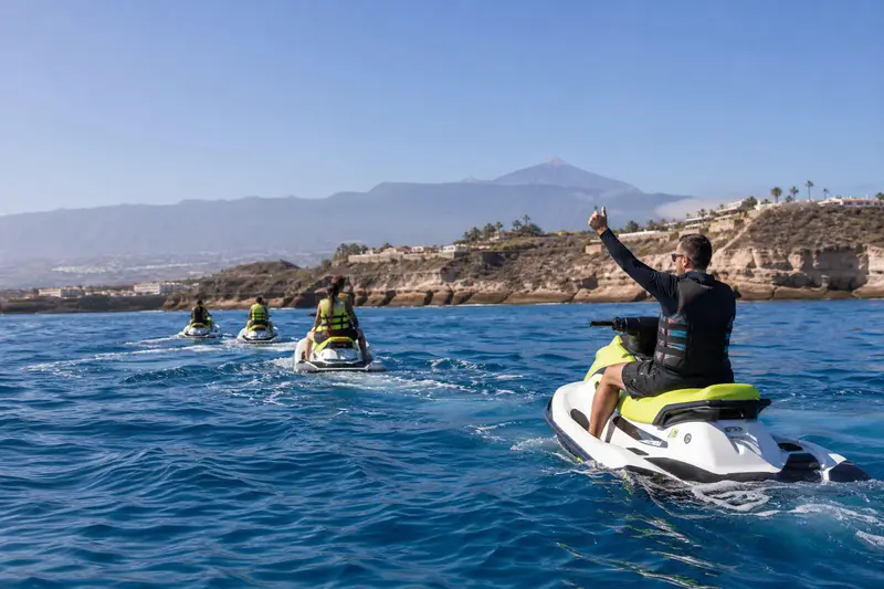 Moniteur expliquant des consignes de sécurité à deux participants près d’un jet ski à Puerto Colón, dans le sud de Tenerife.
