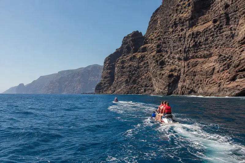 Jet ski naviguant au large des falaises de Los Gigantes à Tenerife, par mer calme le matin.