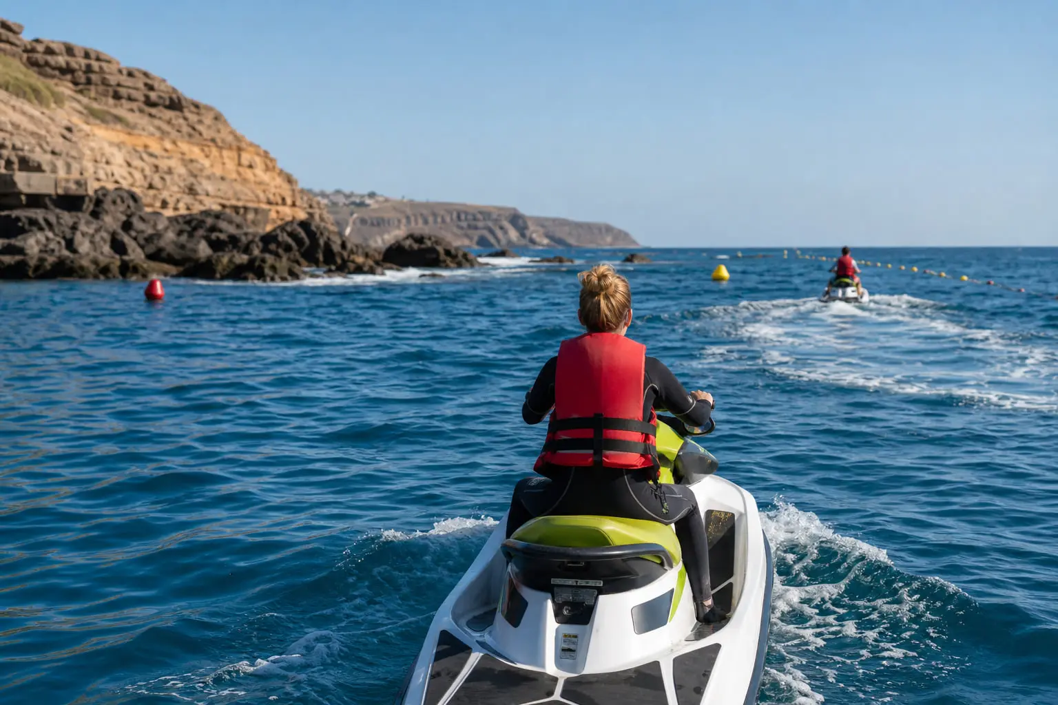 Jet skis espacés dans un circuit balisé au large de Costa Adeje, avec gilets de sauvetage et mer calme le matin à Tenerife.