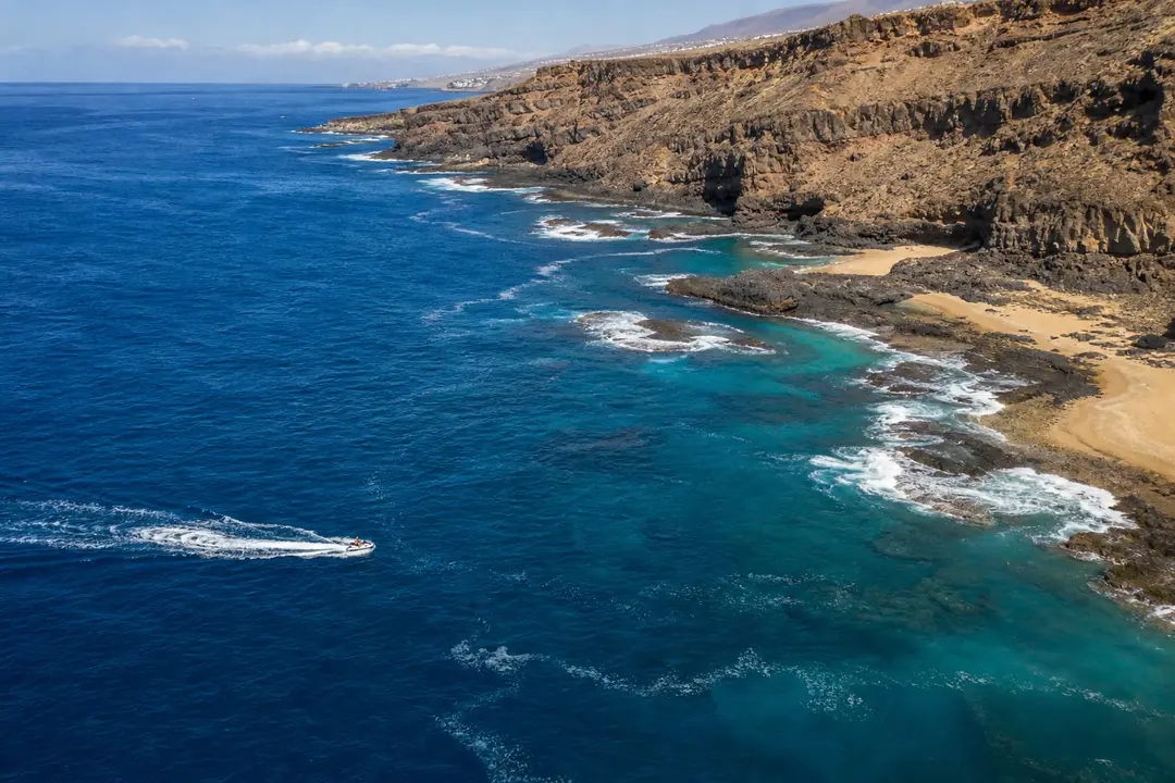 Jet ski encadré au large de Costa Adeje, avec Puerto Colón et la côte sud-ouest de Tenerife en arrière-plan.