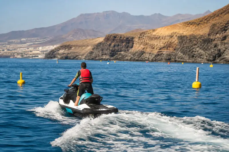 Deux jet skis naviguant à distance de sécurité sur la côte sud de Tenerife au calme le matin.