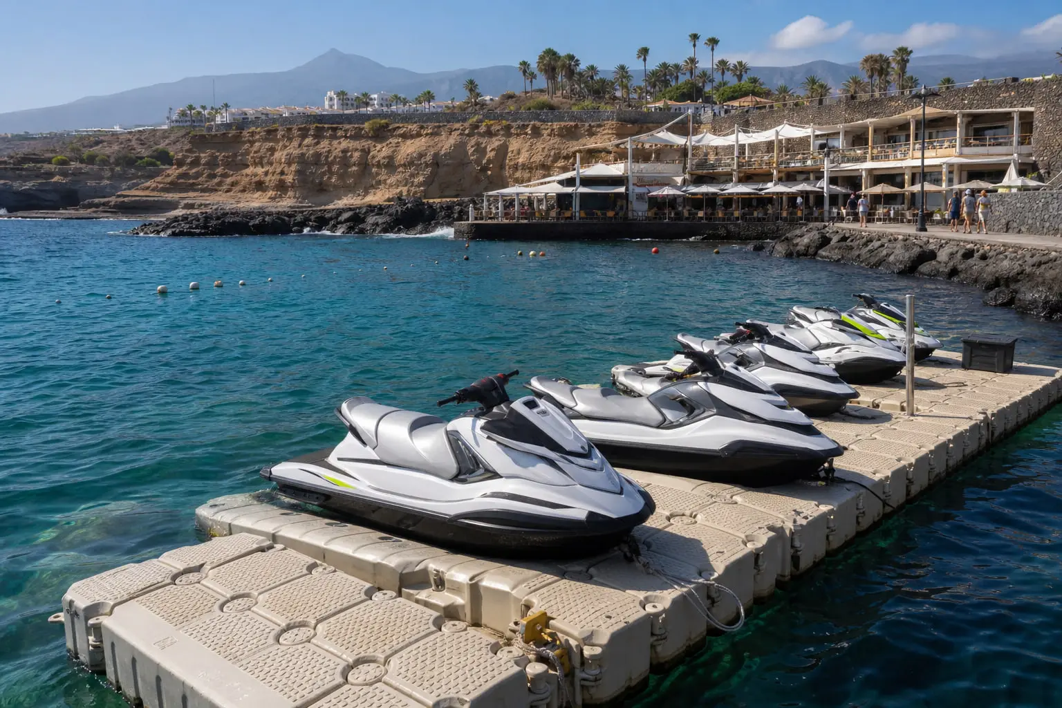 Terrasse de restaurant près de la marina de Puerto Colón à Costa Adeje, avec des jet skis amarrés au loin à Tenerife.